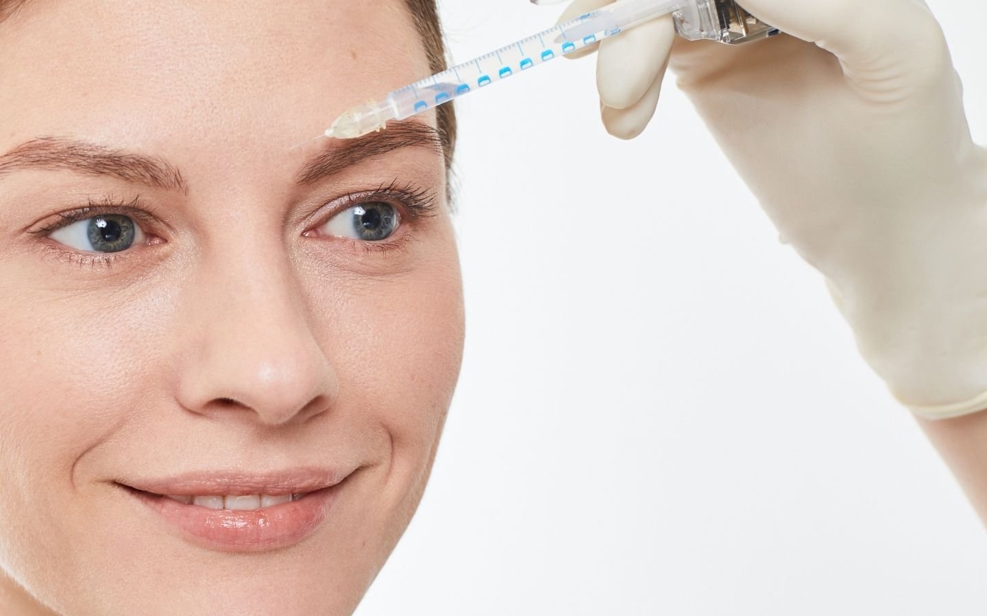 injection de toxine sur la zone entre les yeux d'une femme