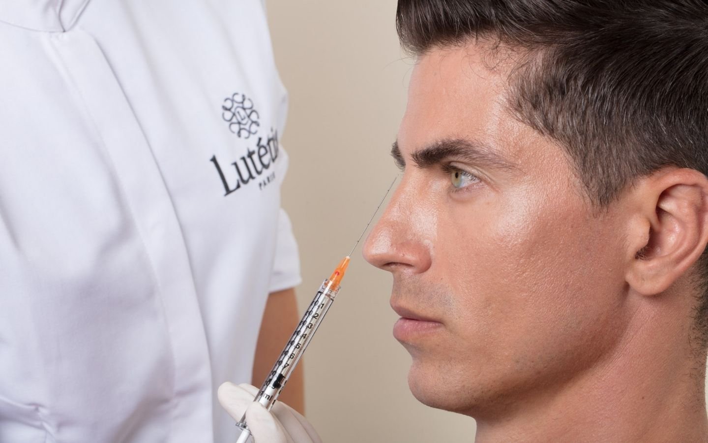 Médecin esthétique réalisant une séance d'acide hyaluronique sur un homme